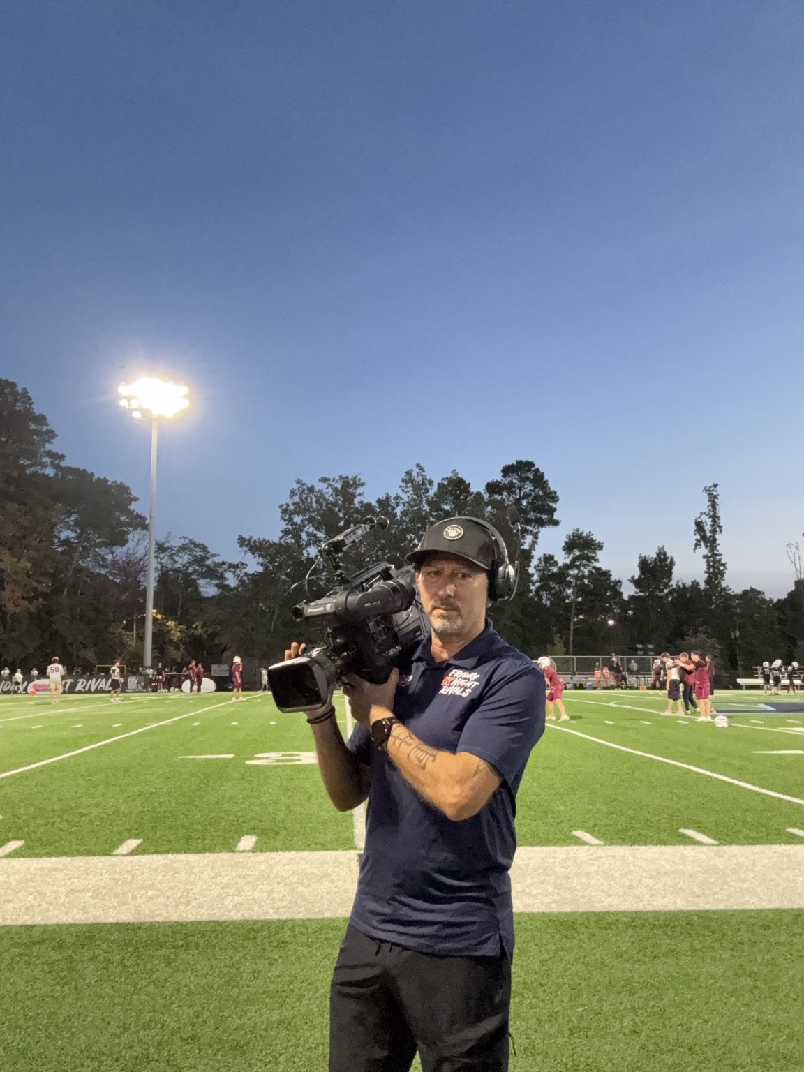 Sergio Myers with a broadcast camera on the Friday Night Rivals football field